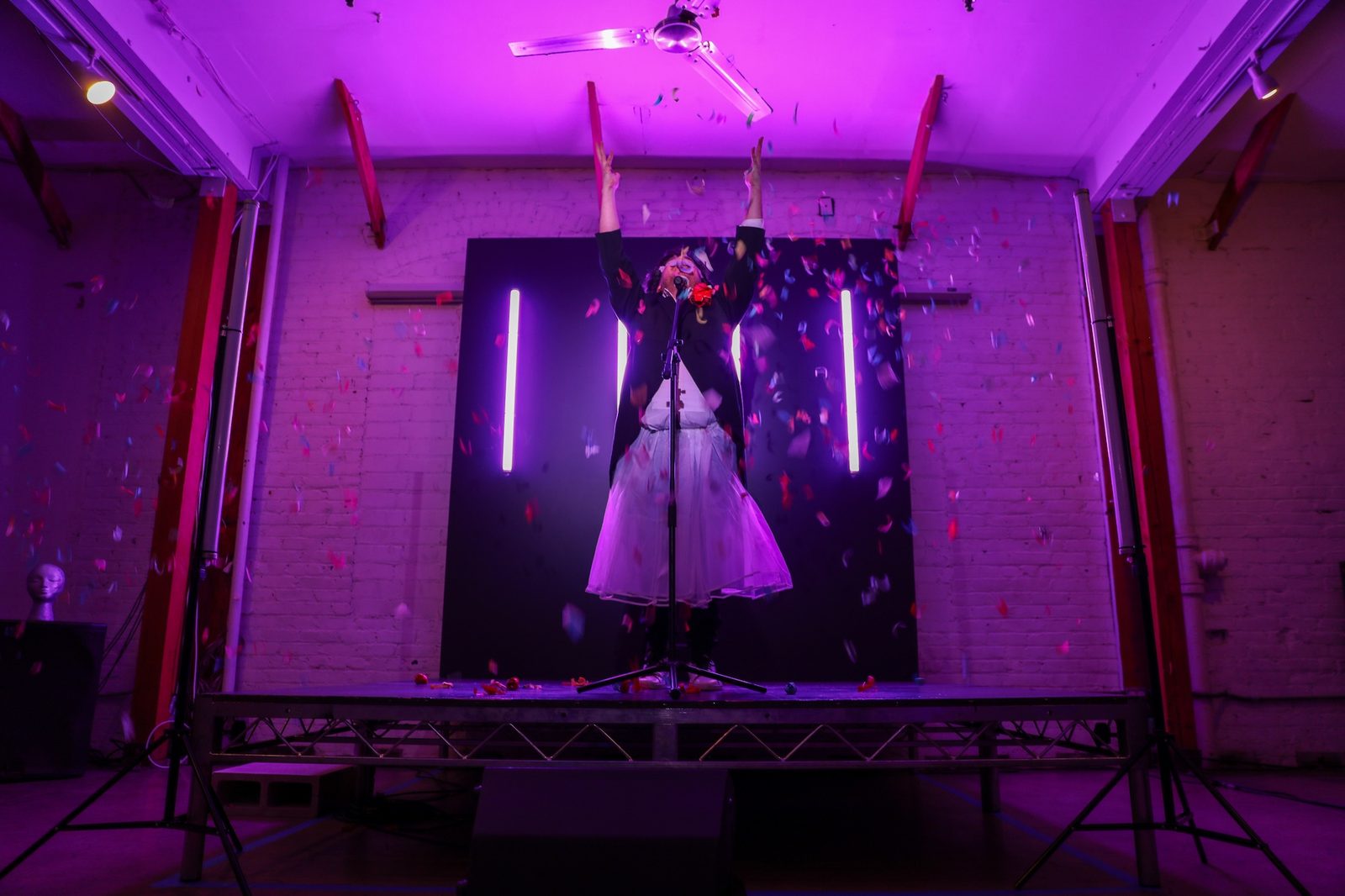 The Judy Garland moment — confetti, white dress, arms raised. LINT, Los Angeles. Photo by Roman Udalov.